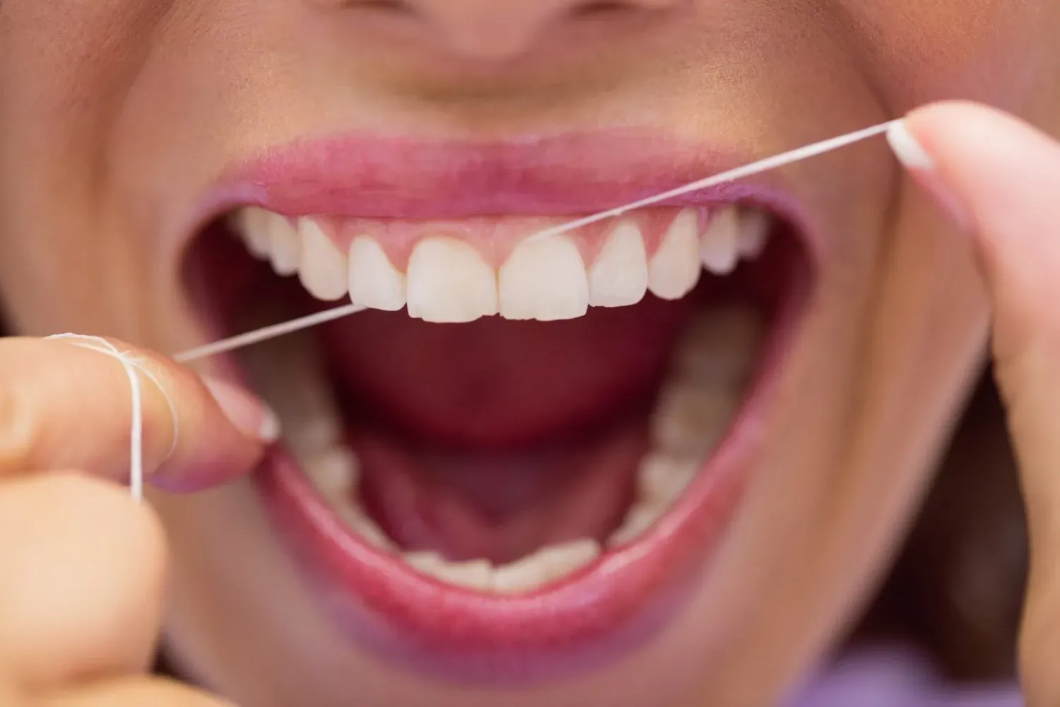 female-patient-flossing-her-teeth.webp